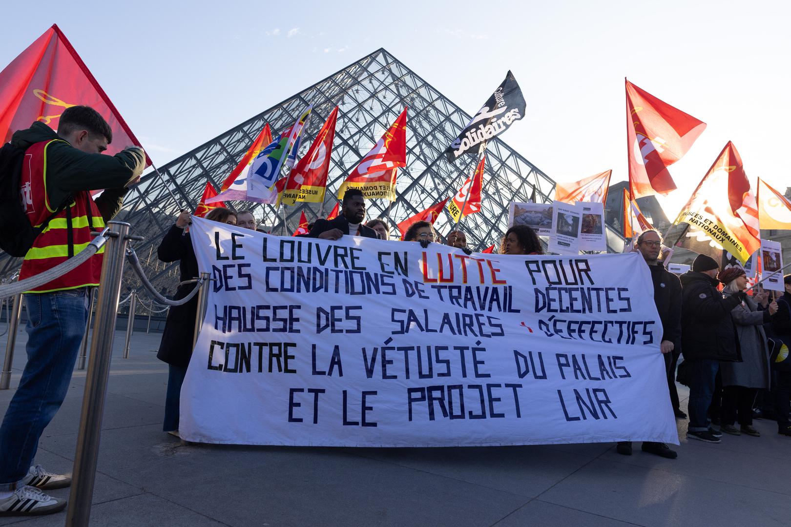 Museum staff hold banners outside the Pyramid of the Louvre Museum as workers voted to go on strike against increasingly deteriorating working conditions and the declining visitor experience at the world famous museum, in Paris on December 15, 2025. Photo by Raphael Lafargue/ABACAPRESS.COM Photo: Lafargue Raphael/ABACA/ABACA