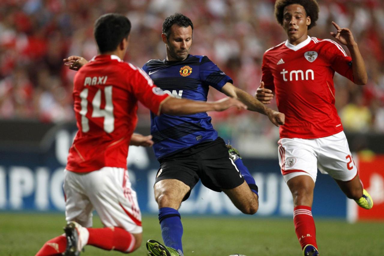 \'Manchester United\'s Ryan Giggs (C) kicks for the goal between Benfica\'s Maxi Pereira (L) and Axel Witsel during the Champions League Group C soccer match at the Luz stadium in Lisbon September 14,