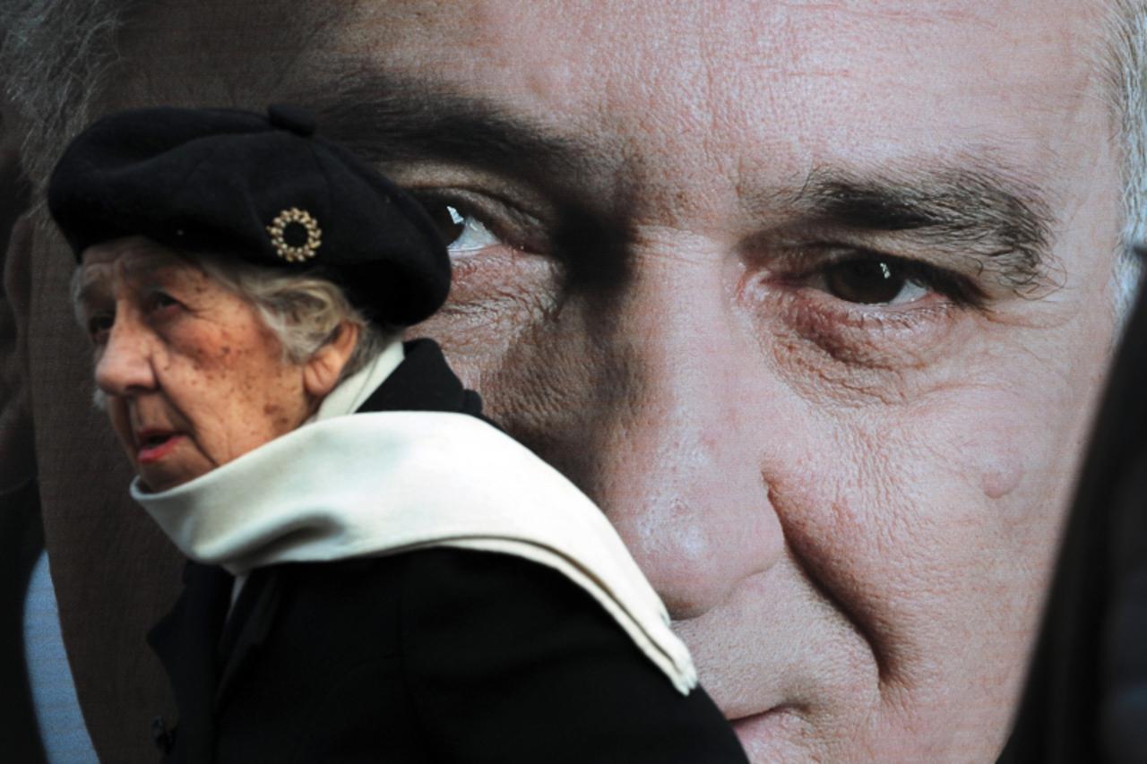 'A woman passes by a pre-election poster showing Serbian ultranationalist Radical Party leader Tomislav Nikolic in Belgrade, 31 January 2008. Nationalist hardliner Tomislav Nikolic won the first round