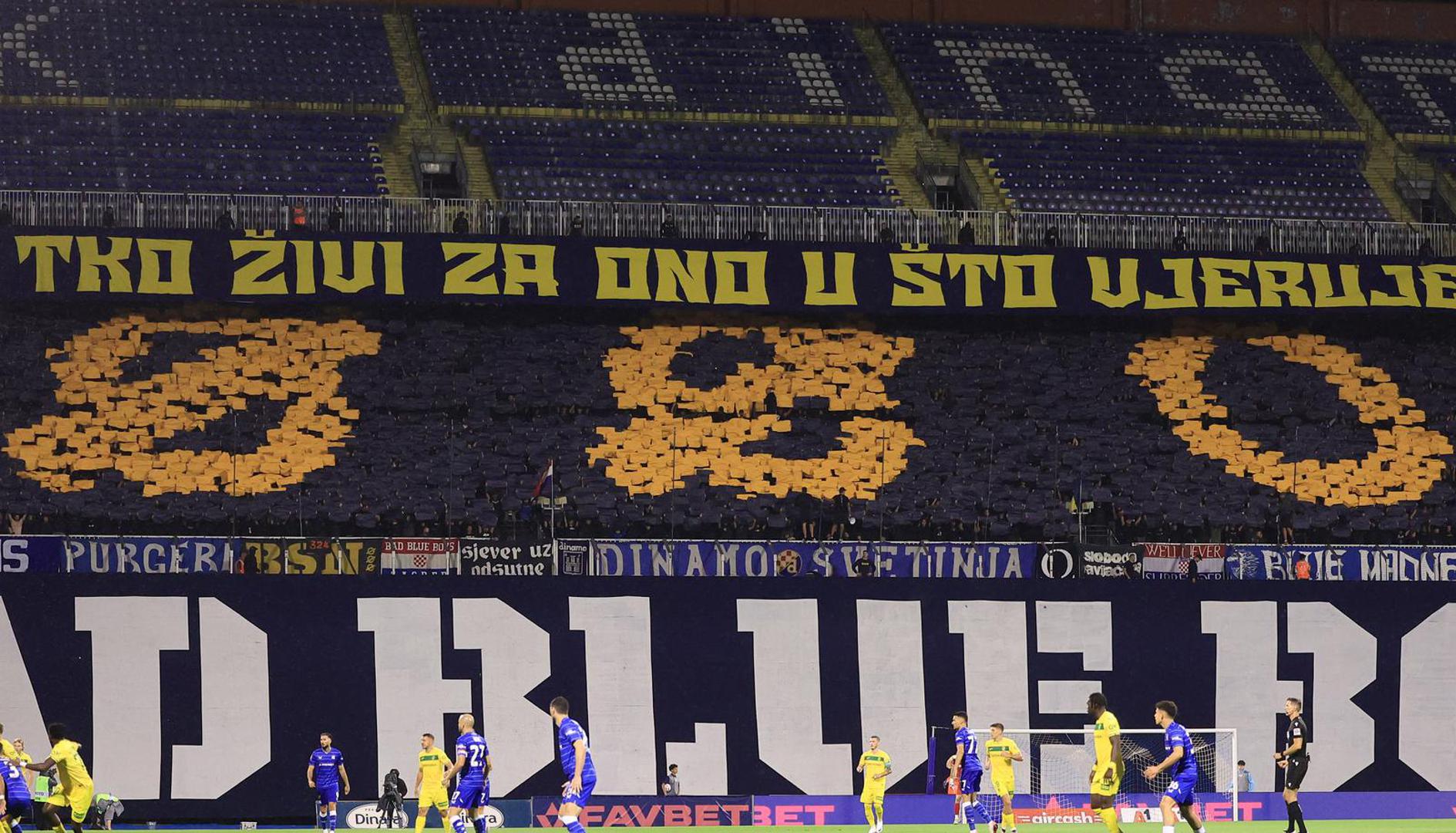 "Tko živi za ono u što vjeruje", stajalo je na tribini. Time su obilježili usvajanje novog Statuta GNK Dinamo. Podno toga je pisalo BSN, akronim za "Borba se nastavlja".