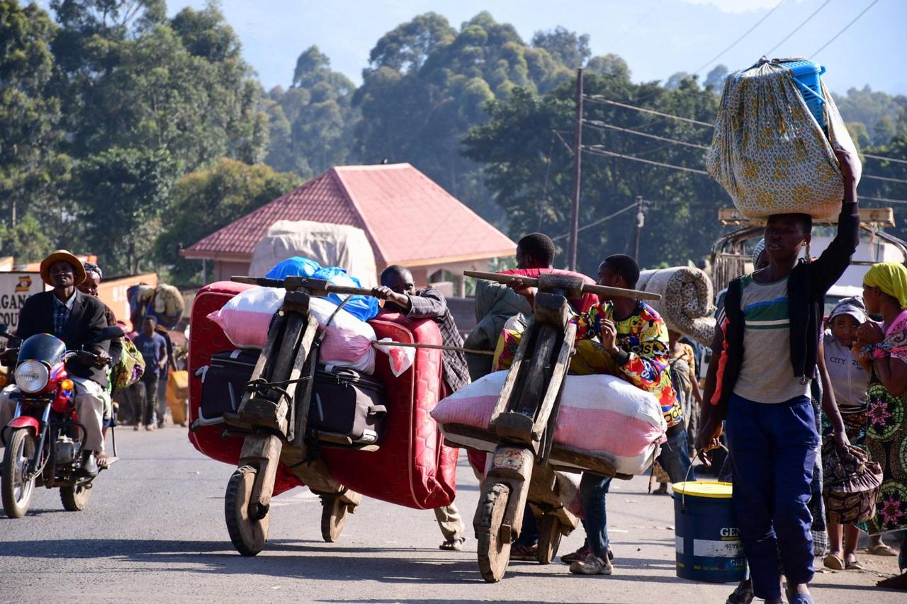 Congolese civilians carry their belongings at the Bunagana border crossing point