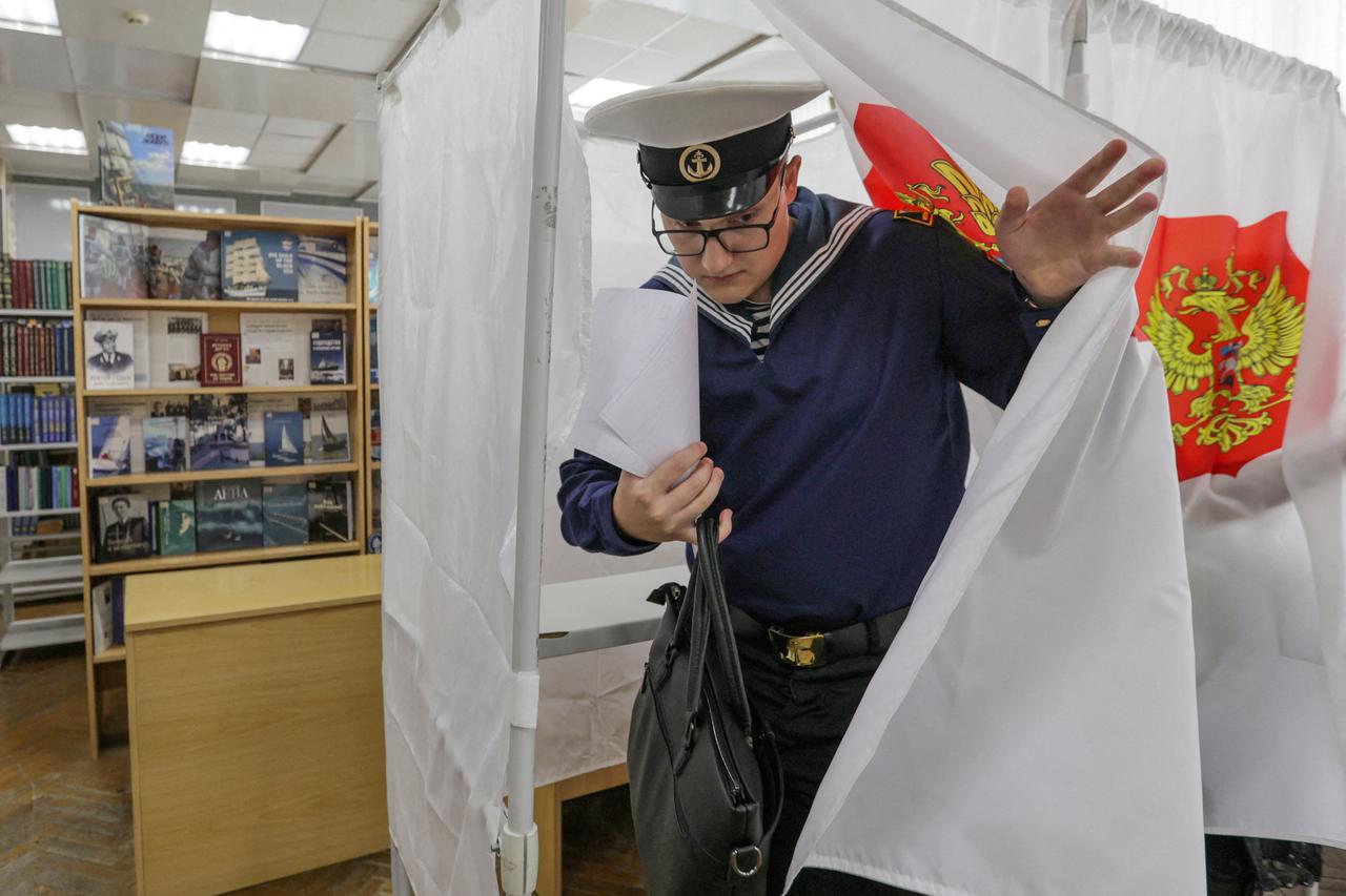 A voter leaves a voting booth before casting his ballot at a polling station on the first day of Russia's parliamentary election in Vladivostok, Russia