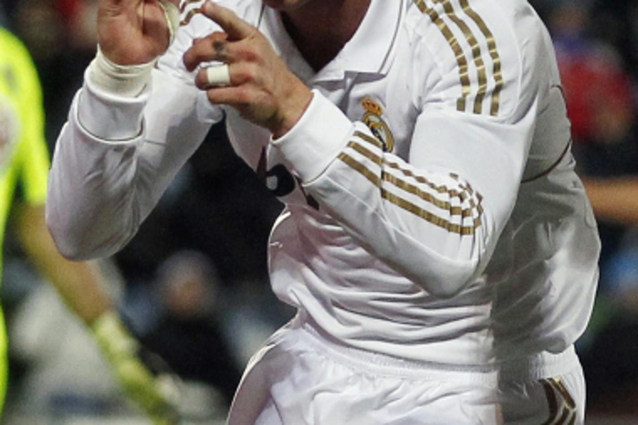 'Real Madrid\'s Sergio Ramos celebrates after scoring against Getafe during their Spanish First Division soccer match at Colisseum Alfonso Perez stadium in Getafe February 4, 2012. REUTERS/Juan Medina