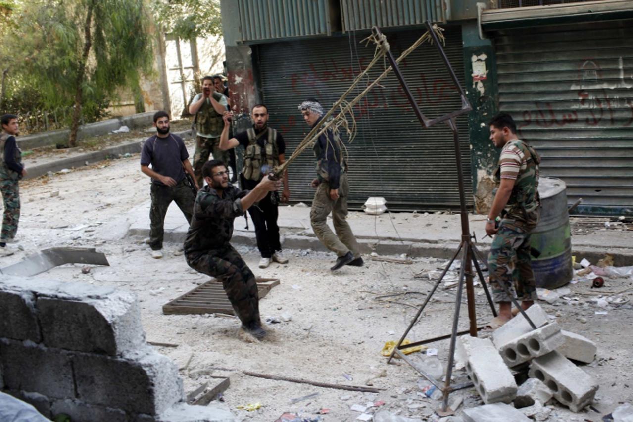 'Members of the free Syrian Army use a catapult to launch a homemade bomb during clashes with pro-government soldiers in the city of Aleppo, October, 15, 2012. REUTERS/Asmaa Waguih (SYRIA - Tags: POLI