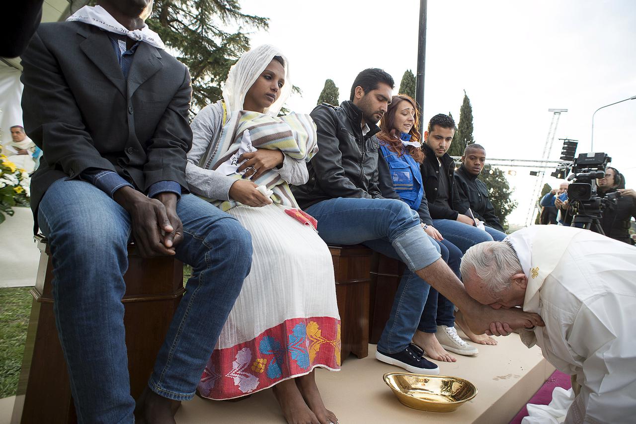 Pope Francis kisses the foot of a refugee during the foot-washing ritual at the Castelnuovo di Porto refugees center near Rome, Italy, March 24, 2016. Pope Francis on Thursday washed and kissed the feet of refugees, including three Muslim men, and condemn