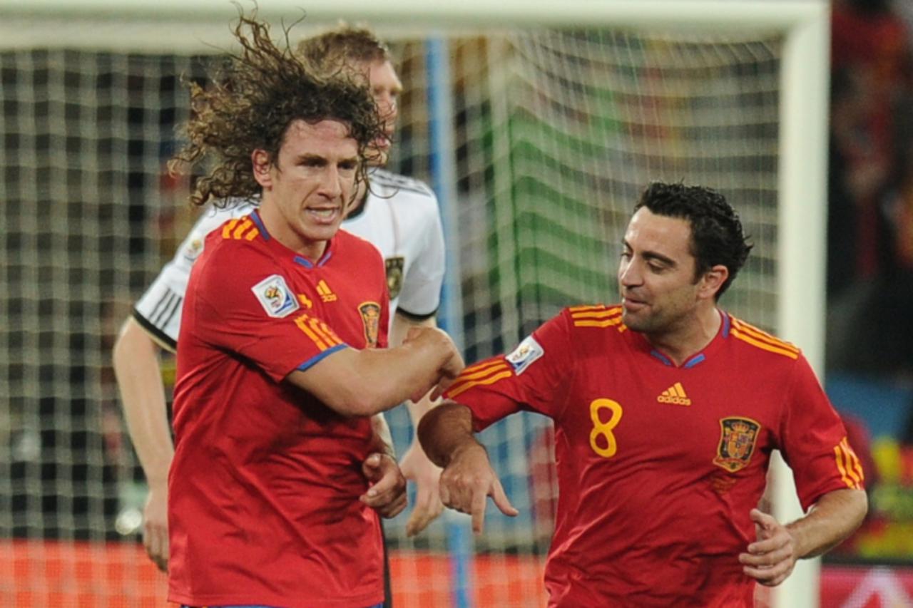 'Spain\'s defender Carles Puyol (5) celebrates with Spain\'s midfielder Xavi (R) after scoring during the 2010 World Cup semi final Germany vs Spain on July 7, 2010 at the Moses Mabhida stadium in Dur