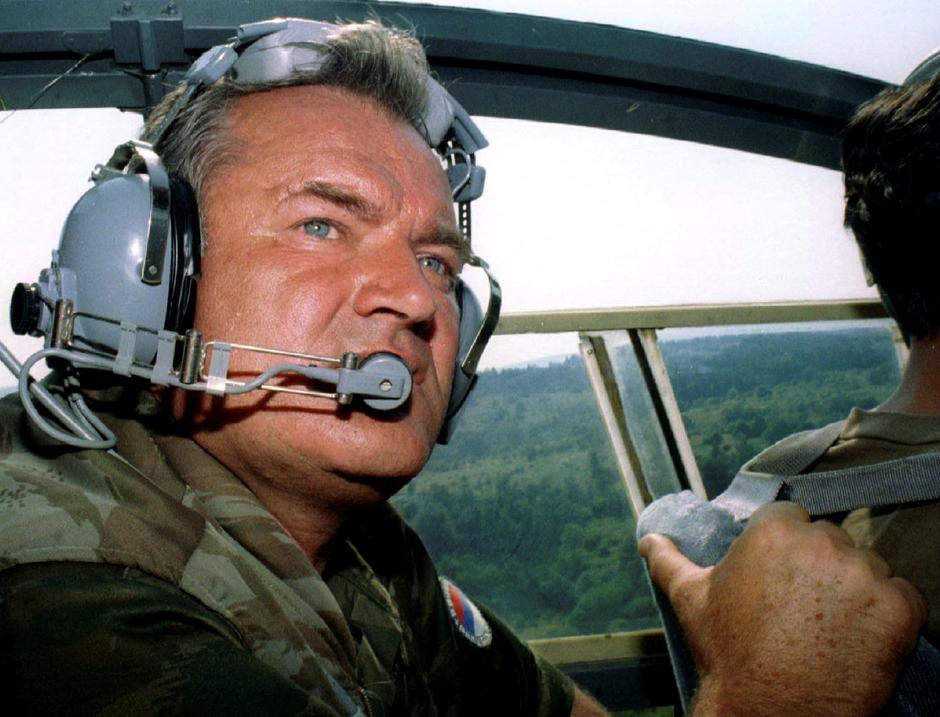 FILE PHOTO: Bosnian Serb army Commander General Ratko Mladic wears head-phones while travelling in helicopter ne..