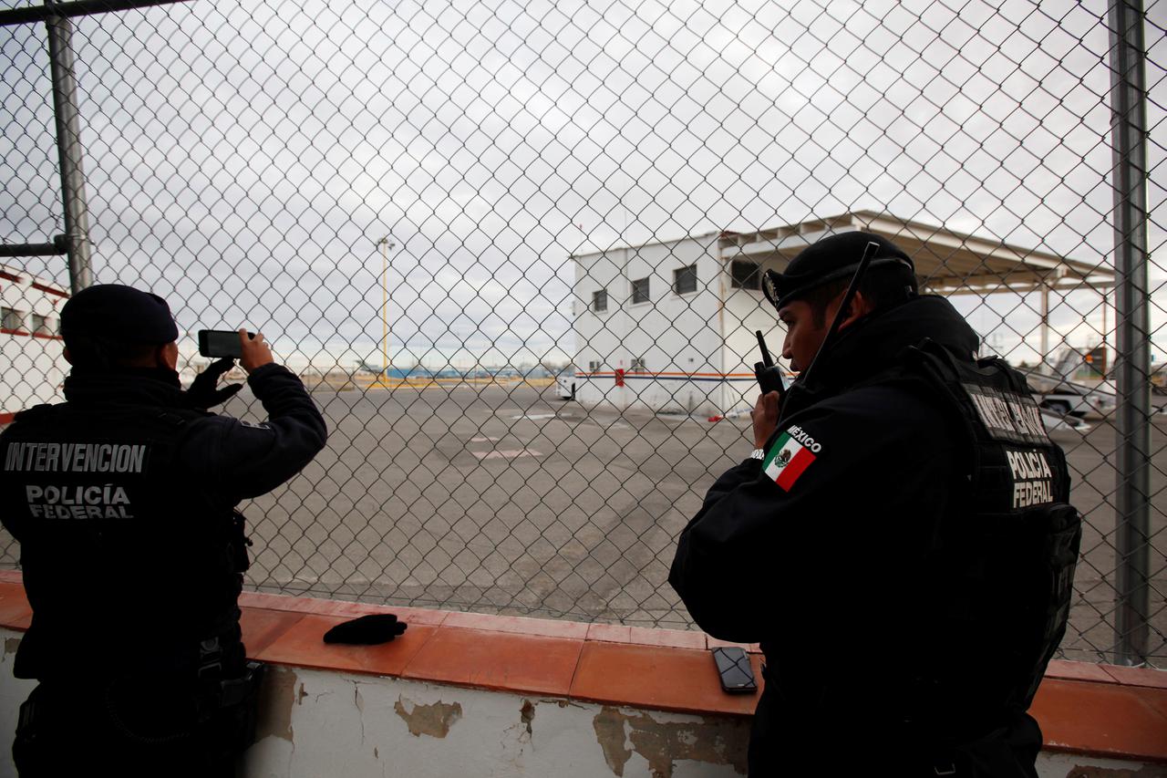 Federal police officers stand at a fence surrounding a private landing strip, as signs of increased security are seen next to the international airport in Ciudad Juarez, Mexico, January 19, 2017. Notorious Mexican drug lord Joaquin 