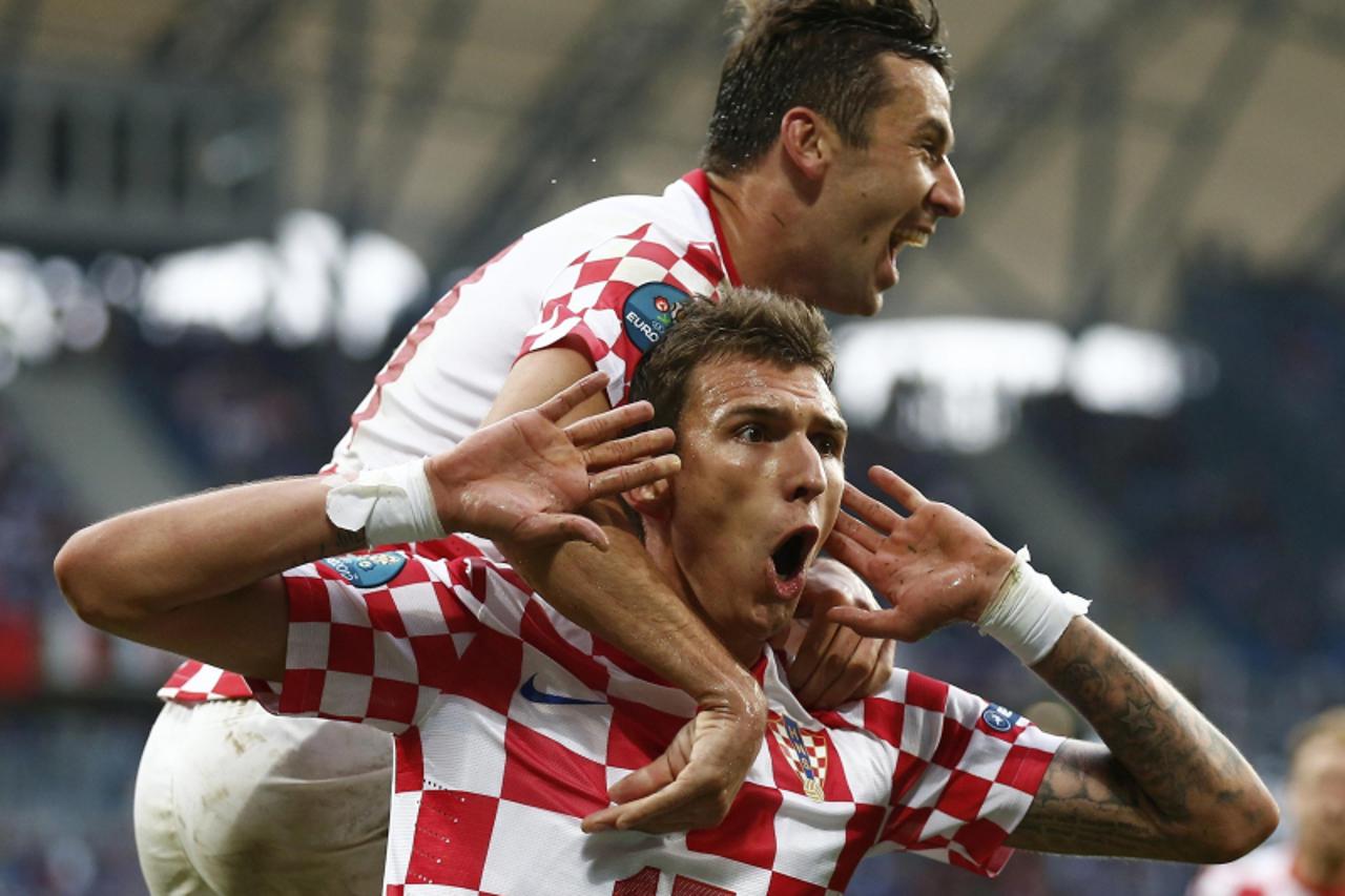'Croatia\'s Mario Mandzukic (bottom) celebrates with Darijo Srna after scoring a goal against Italy during their Group C Euro 2012 soccer match at the city stadium in Poznan June 14, 2012.    REUTERS/