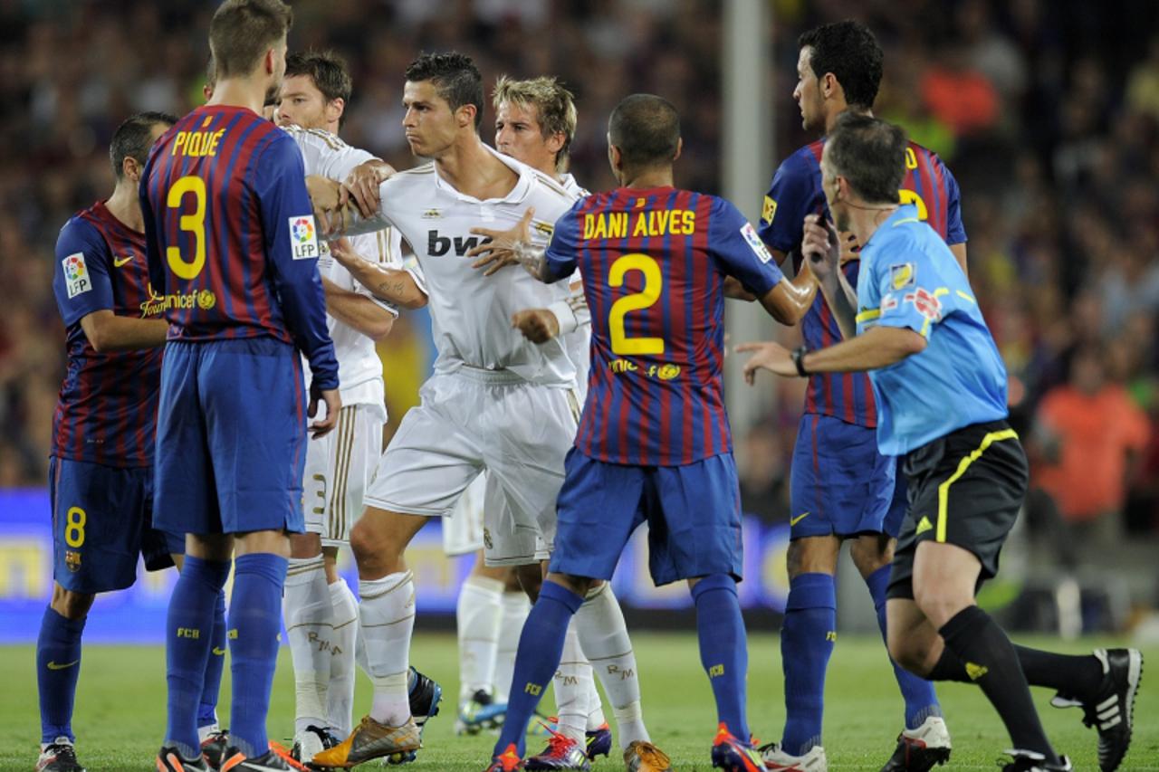 \'Real Madrid\'s Portuguese forward Cristiano Ronaldo (C) argues with Barcelona\'s defender Gerard Pique (2ndL)during the second leg of the Spanish Supercup football match FC Barcelona vs Real Madrid 