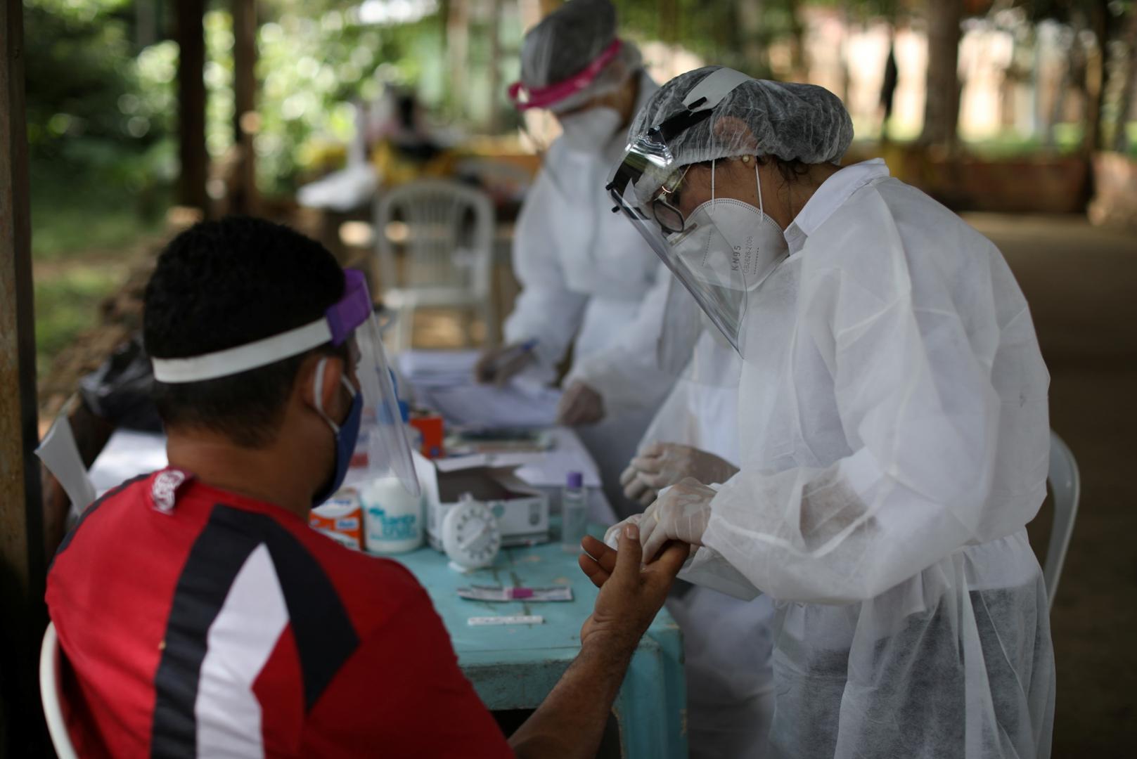 Outbreak of the coronavirus disease (COVID-19), in Manaus A health worker conducts a test for the coronavirus disease (COVID-19) with a man in the Bela Vista do Jaraqui, in the Conservation Unit Puranga Conquista along the Negro River banks, where Ribeirinhos (forest dwellers) live, amid the coronavirus disease (COVID-19) outbreak, in Manaus, Brazil, May 29, 2020. REUTERS/Bruno Kelly BRUNO KELLY