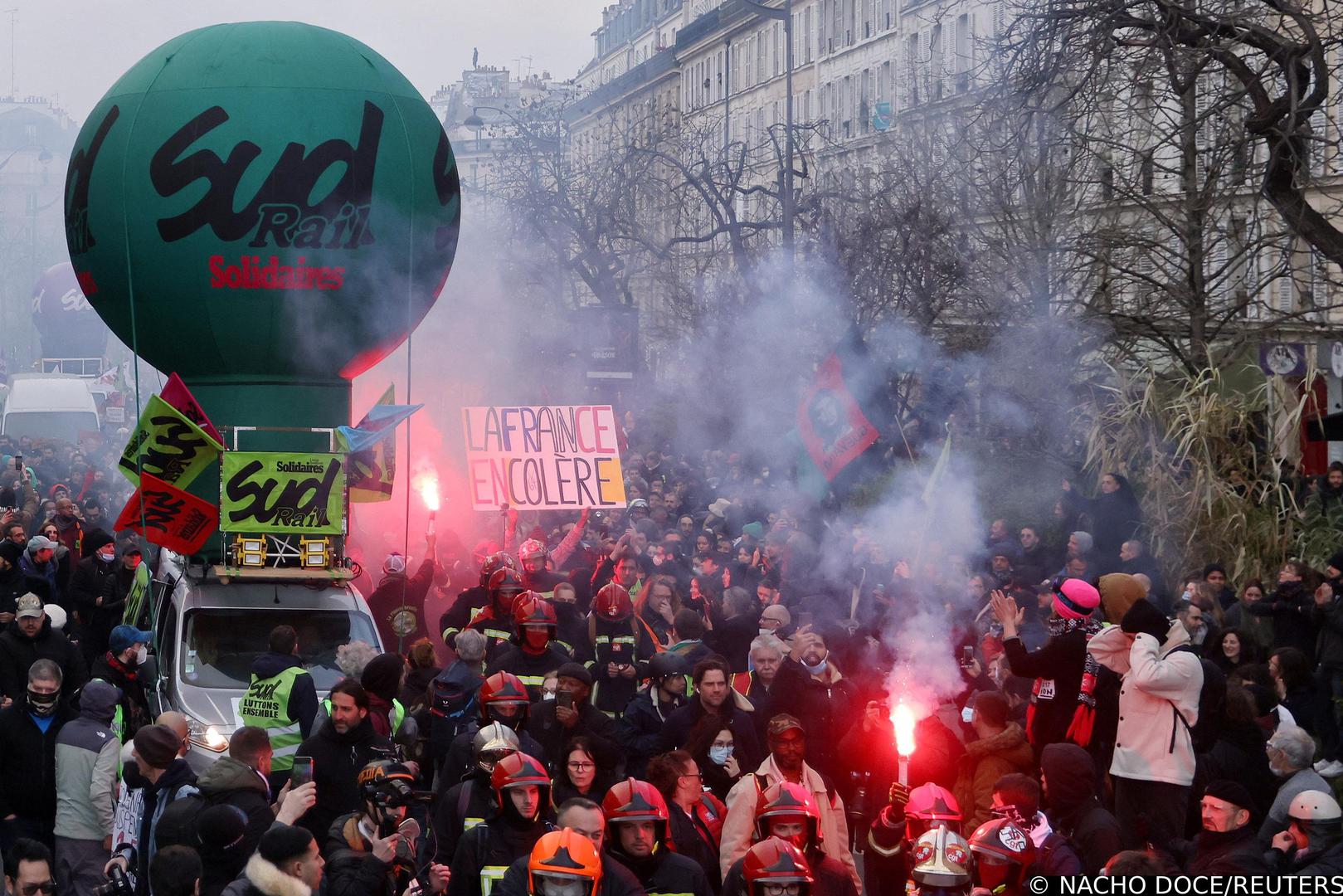 French firefighters on strike and protesters walk past the balloon of Sud Rail Solidaires labour union a demonstration as part of the tenth day of nationwide strikes and protests against French government's pension reform in Paris, France, March 28, 2023.   REUTERS/Nacho Doce Photo: NACHO DOCE/REUTERS
