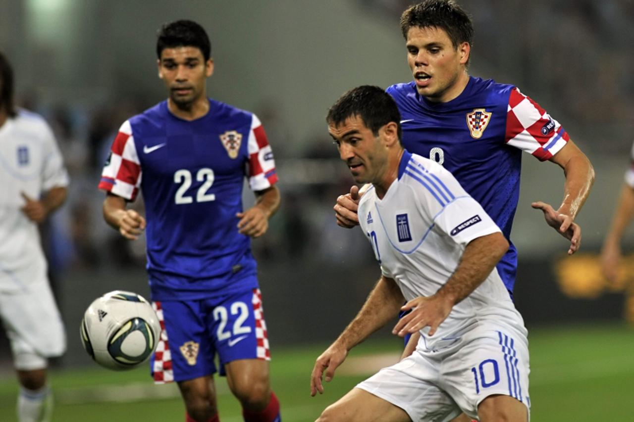 \'Greece\'s  Gergios Karagounis (C) vies with Croatia\'s Ognjen Vukojevic (R) and Eduardo da Silva (L) during their qualification match for the Euro 2012 at the Karaiskaki stadium in Piraeues near Ath