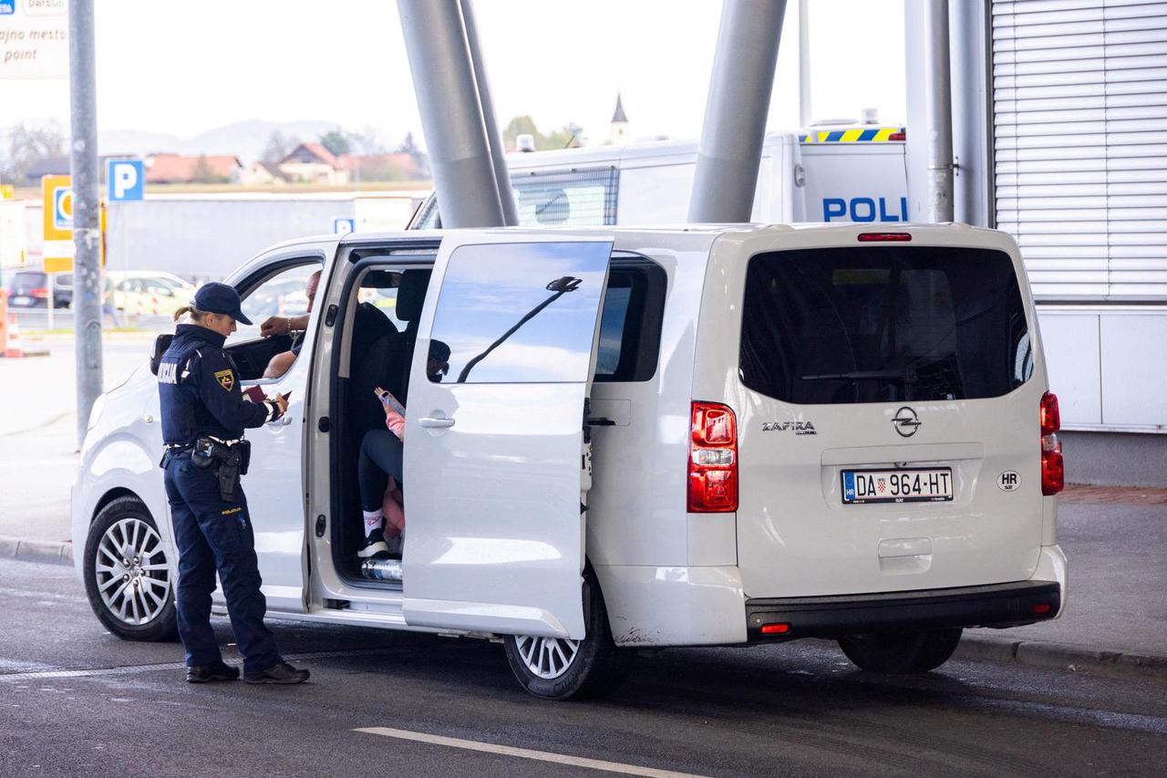 Police officers inspect documents at the border crossing in Obrezje