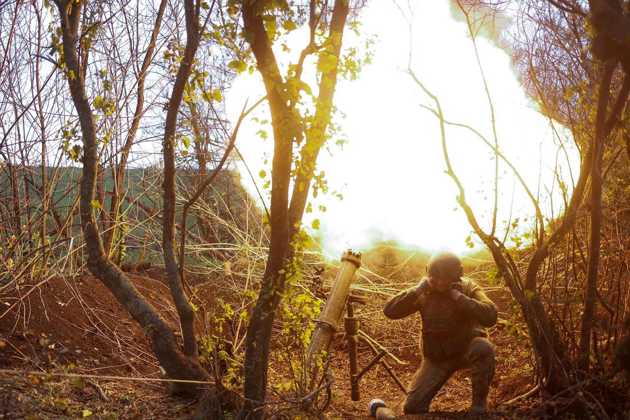 Ukrainian serviceman fires with a mortar toward Russian positions in a frontline in Mykolaiv region