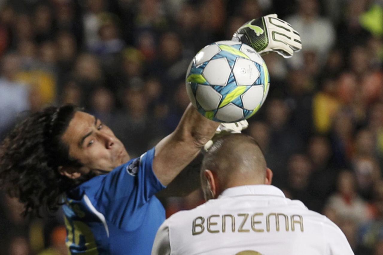 'APOEL\'s goalkeeper Dionisios Chiotis (L) saves the ball from a header of Real Madrid\'s Karim Benzema during their Champions League quarter-final first leg soccer match at GSP stadium in Nicosia Mar