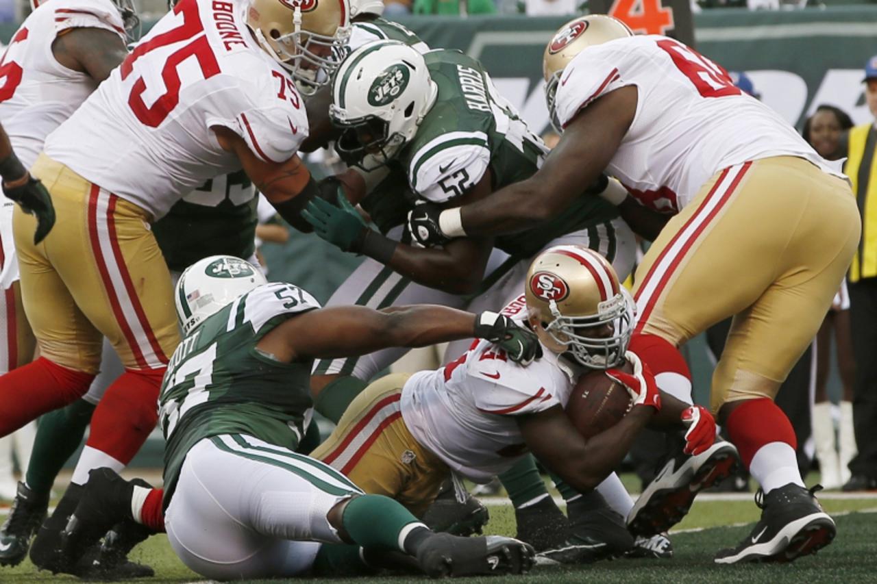 'San Francisco 49ers running back Frank Gore dives for a touchdown past New York Jets\' Bart Scott (L, 57) during the third quarter of their NFL football game in East Rutherford, New Jersey September 