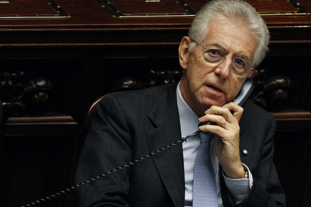 'Italy\'s Prime Minister Mario Monti talks on the phone during a vote of confidence at the Lower House of Parliament in Rome, in this file photo taken November 18, 2011. With Italy fighting to emerge 