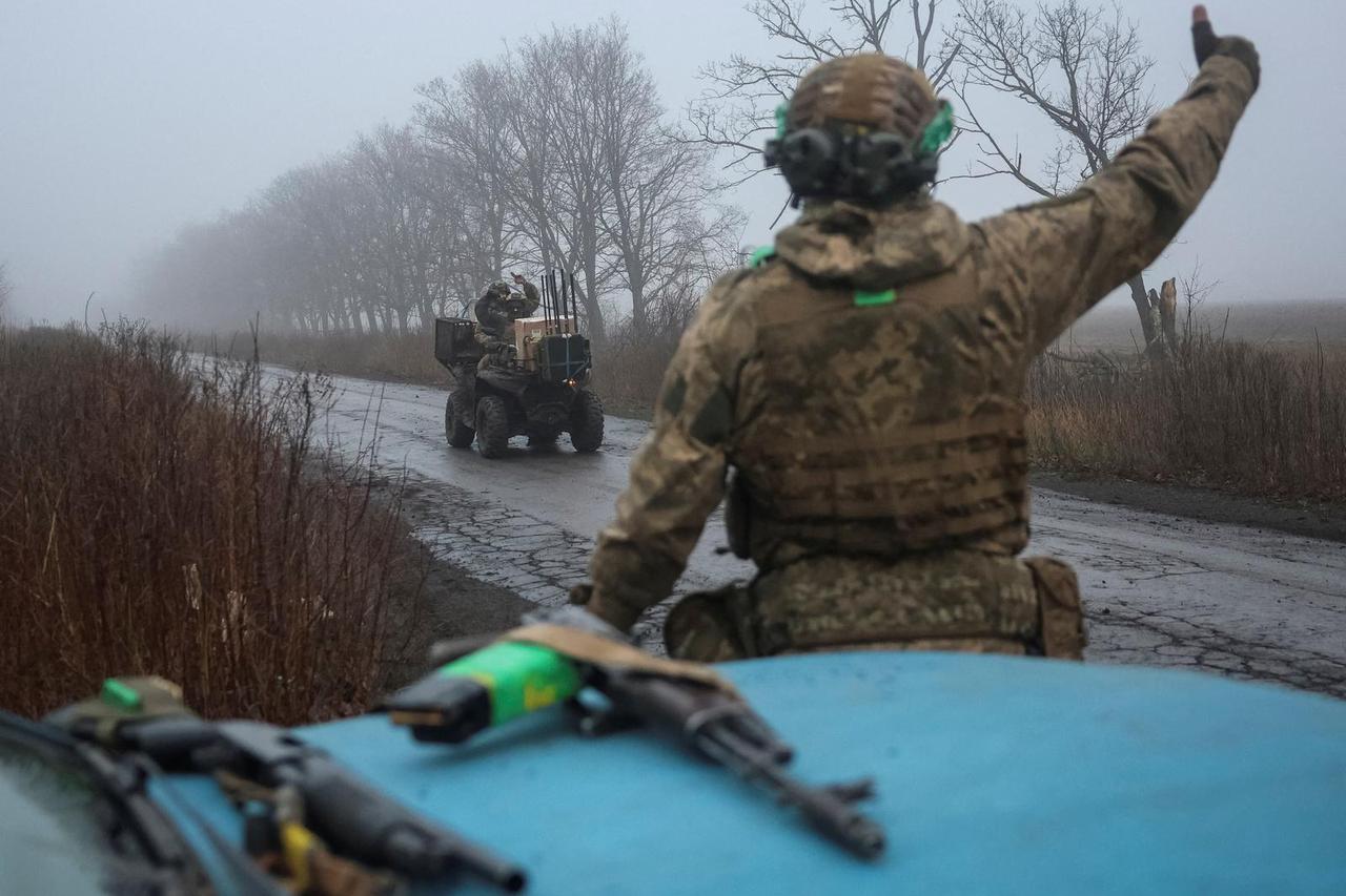 Ukrainian servicemen react as they ride a military buggy after a combat mission near the frontline town of Kostiantynivka