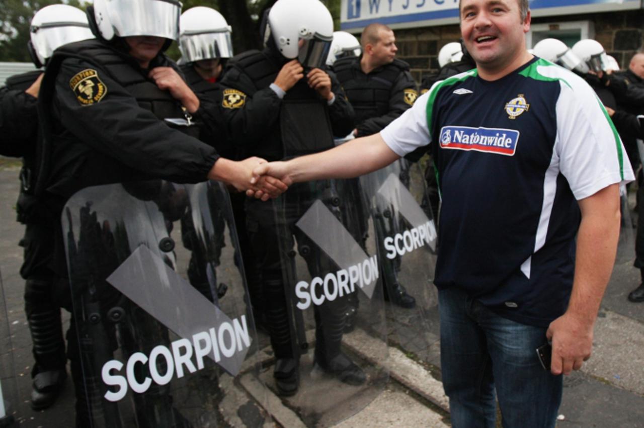 'A Northern Ireland fan with riot police outside the stadium before the World Cup European Qualifying match at the Slaski Stadium, Chorzow, Poland. Photo: Press Association/Pixsell'