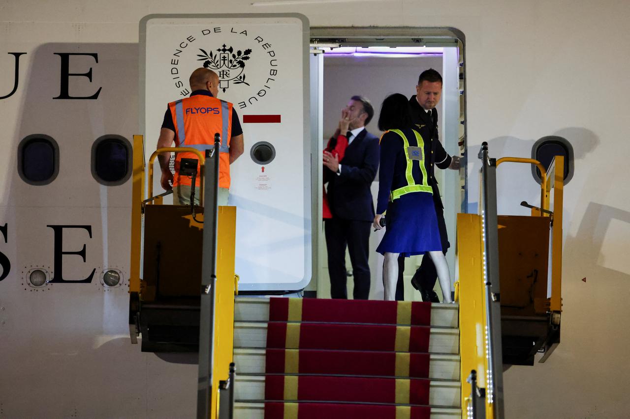 Macron's face appears to be shoved by wife in Vietnam