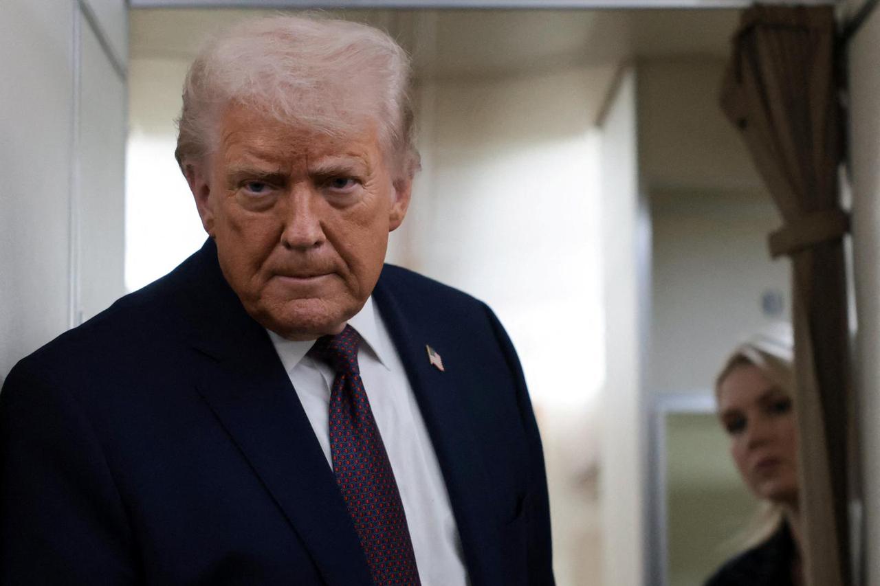 U.S. President Donald Trump speaks to reporters aboard Air Force One