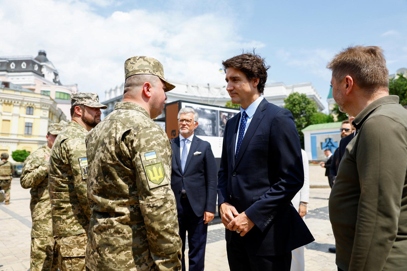 Canadian Prime Minister Justin Trudeau speaks with Ukrainian soldiers as he visits the Wall of Remembrance to pay tribute to killed Ukrainian soldiers, amid Russia's attack on Ukraine, in Kyiv, Ukraine June 10, 2023. REUTERS/Valentyn Ogirenko/Pool Photo: VALENTYN OGIRENKO/REUTERS