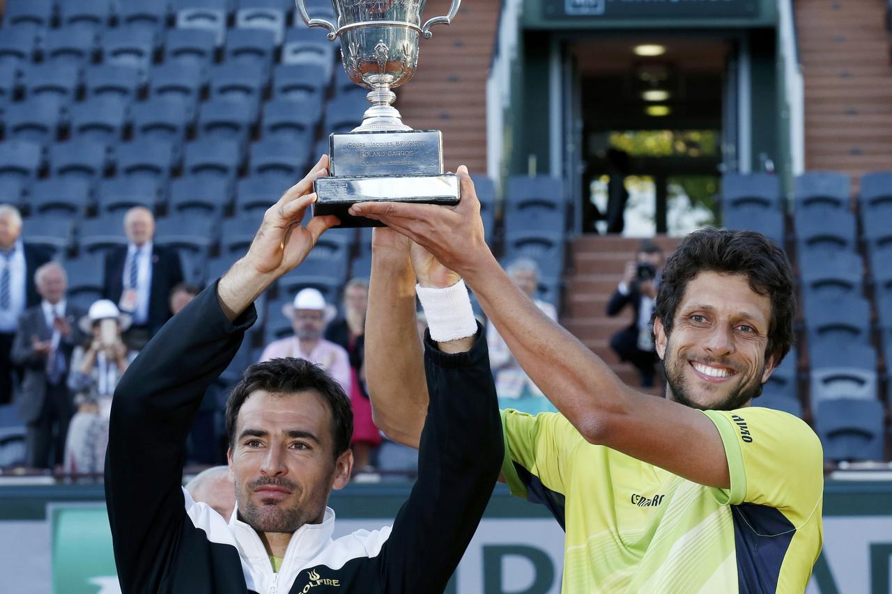 Ivan Dodig of Croatia (L) and Marcelo Melo of Brazil pose with their trophy after defeating Bob Bryan and Mike Bryan of the U.S. in their men's doubles final match at the French Open tennis tournament at the Roland Garros stadium in Paris, France, June 6,