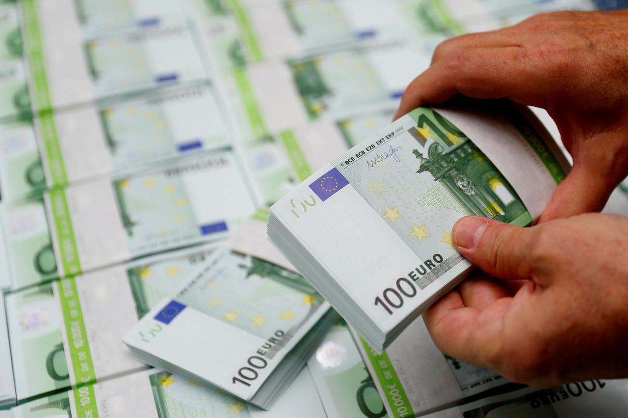 FILE PHOTO: An employee checks 100 Euro banknotes at the Money Service Austria company's headquarters in Vienna