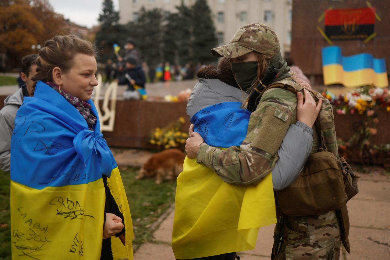 Local resident hugs a Ukrainian servicewoman after Russia's retreat from Kherson, in central Kherson