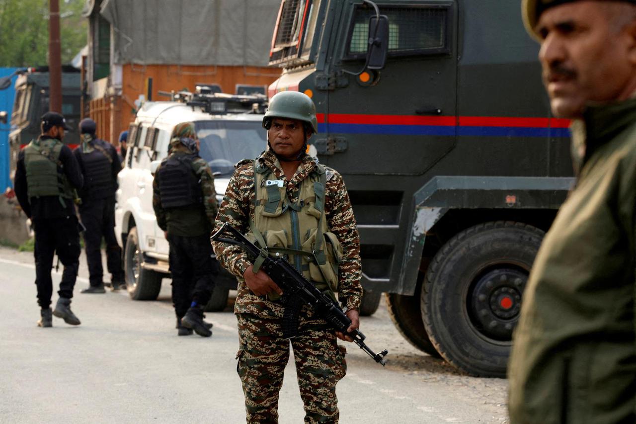 Indian security force personnel stand guard near the site of a fighter jet crash in Wuyan
