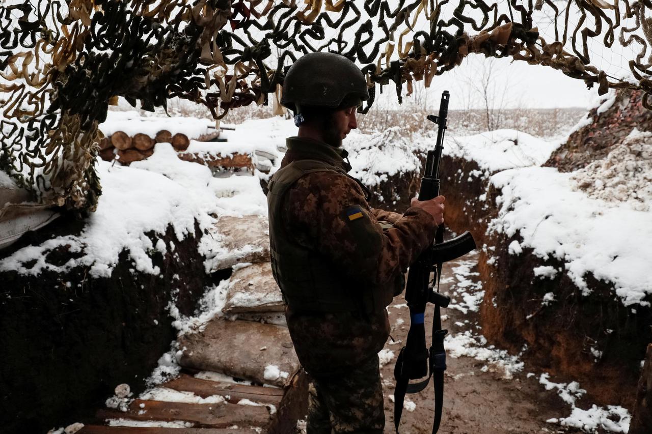 A Ukrainian service member stands in a trench on the front line near the village of Zaitseve