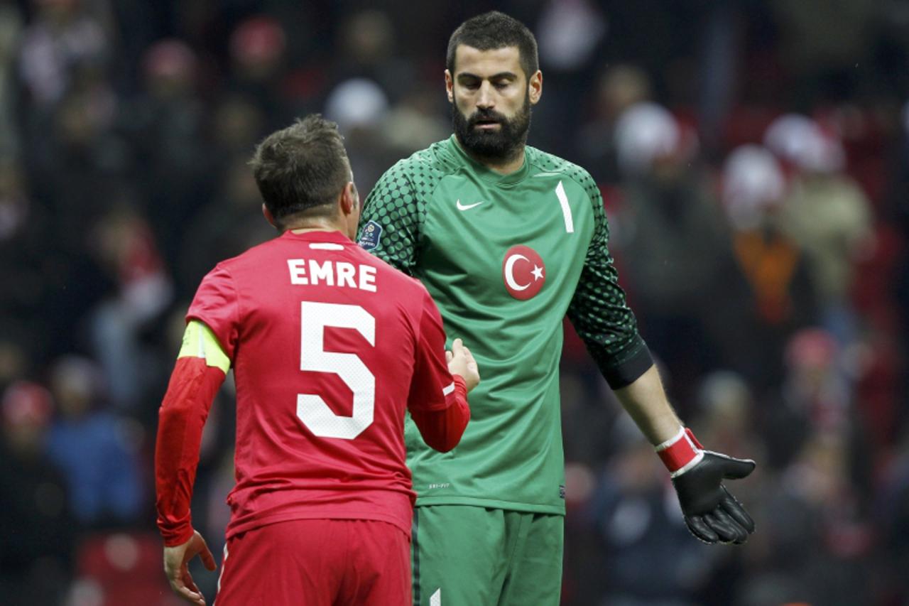 'Turkey\'s Emre Belozoglu (L) discuss with goalkeeper Volkan Demirel (R) during the first leg of their Euro 2012 play-off soccer match against Croatia at Turk Telekom Arena in Istanbul November 11, 20