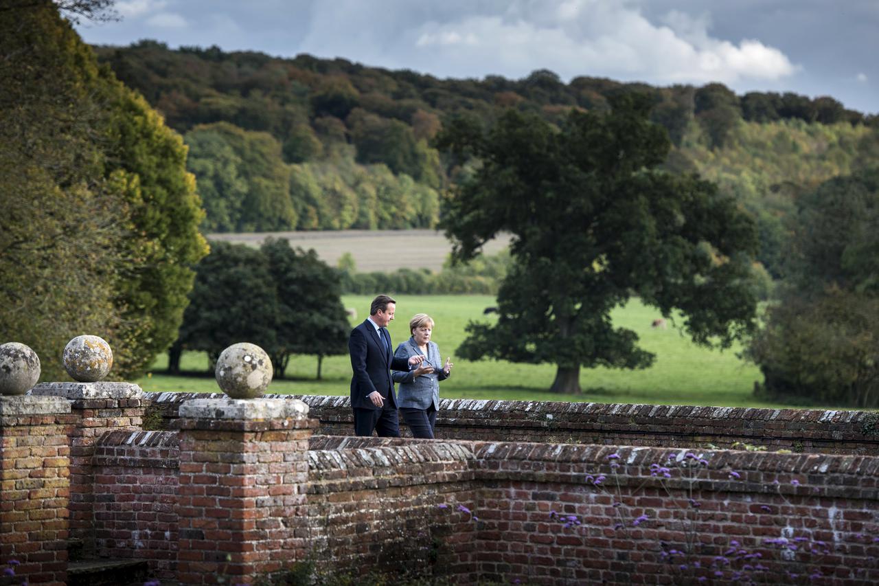 Britain's Prime Minister David Cameron (L) talks to German Chancellor Angela Merkel during a walk at Chequers, the Prime Minister's official country residence, near Ellesborough in southern England, Britain, October 9, 2015. REUTERS/Guido Bergmann/Bundesr