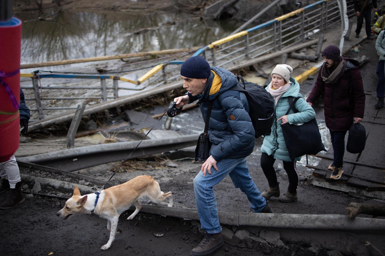 People cross a destroyed bridge as they evacuate the city of Irpin, northwest of Kyiv, during heavy shelling and bombing on March 5, 2022, 10 days after Russia launched a military invasion on Ukraine. Photo by Raphael Lafargue/ABACAPRESS.COM