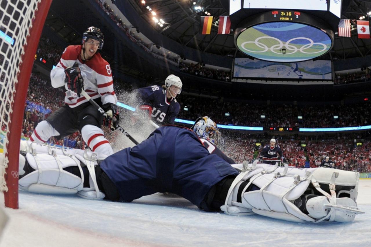 'Canada\'s Sidney Crosby (L) fails to score on a breakaway against goaltender Ryan Miller of the U.S. in the final minutes of the third period in their men\'s ice hockey gold medal game at the Vancouv