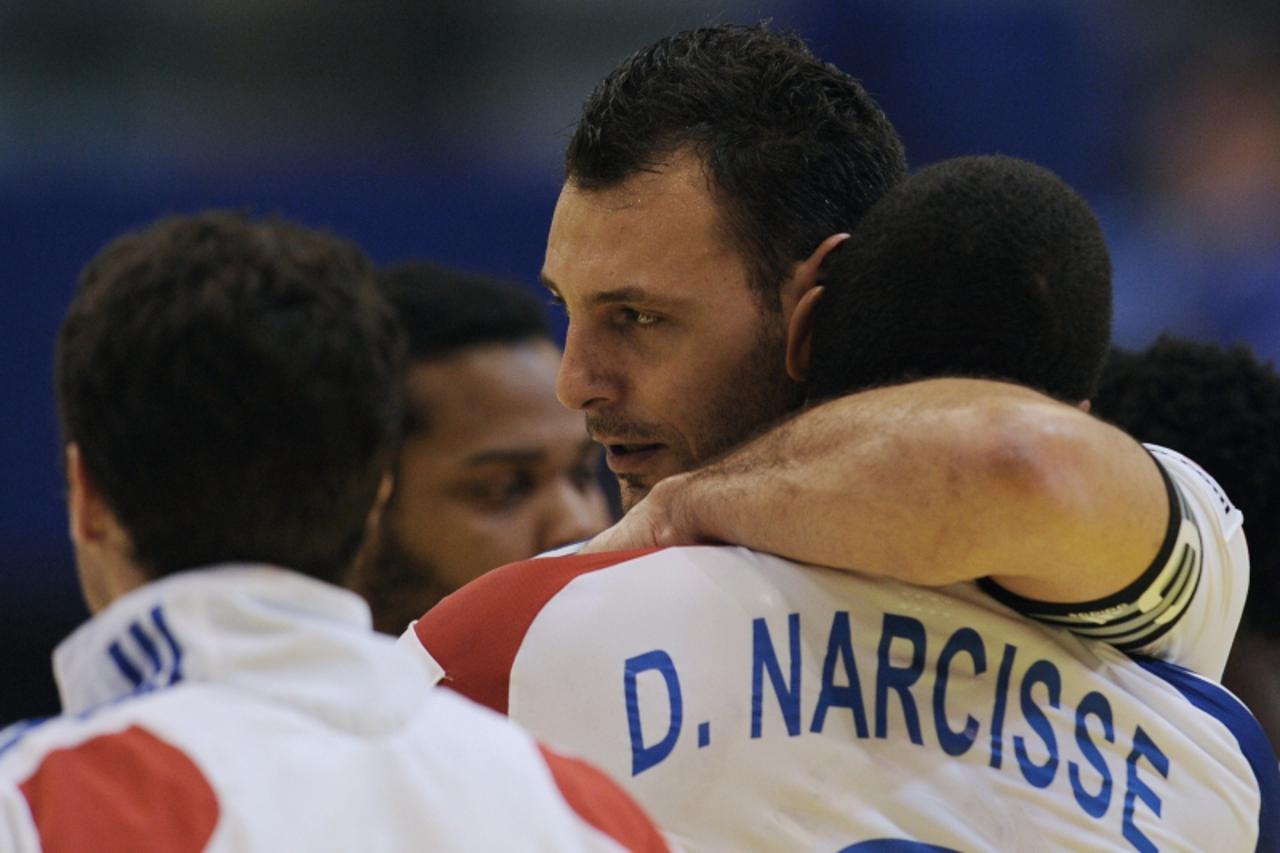 'French captain Jerome Fernandez (C) is congratuled by Daniel Narcisse after their team won against Slovenia during the men\'s EHF Euro 2012 Handball Championship match between France and Slovenia at 