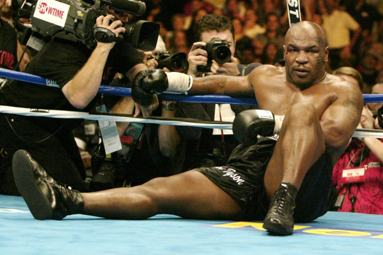 'Mike Tyson of the United States sits on the canvas after being knocked out by Danny Williams of Great Britain in their heavyweight fight in Louisville, July 30, 2004.        REUTERS/Peter Jones'