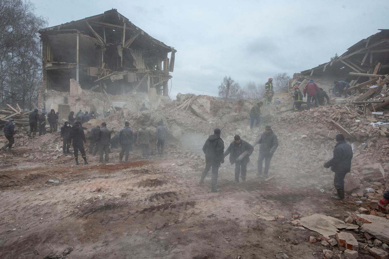 People remove debris at the site of a military base building that, according to the Ukrainian ground forces, was destroyed by an air strike, in the Sumy region