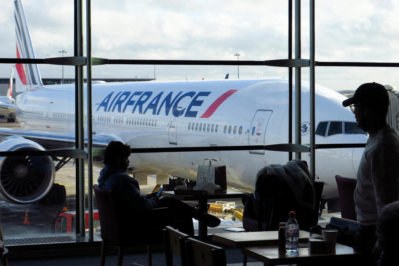 Passengers wait for an Air-France flight inside the Terminal 2 at Paris Charles de Gaulle airport in Roissy-en-France near Paris