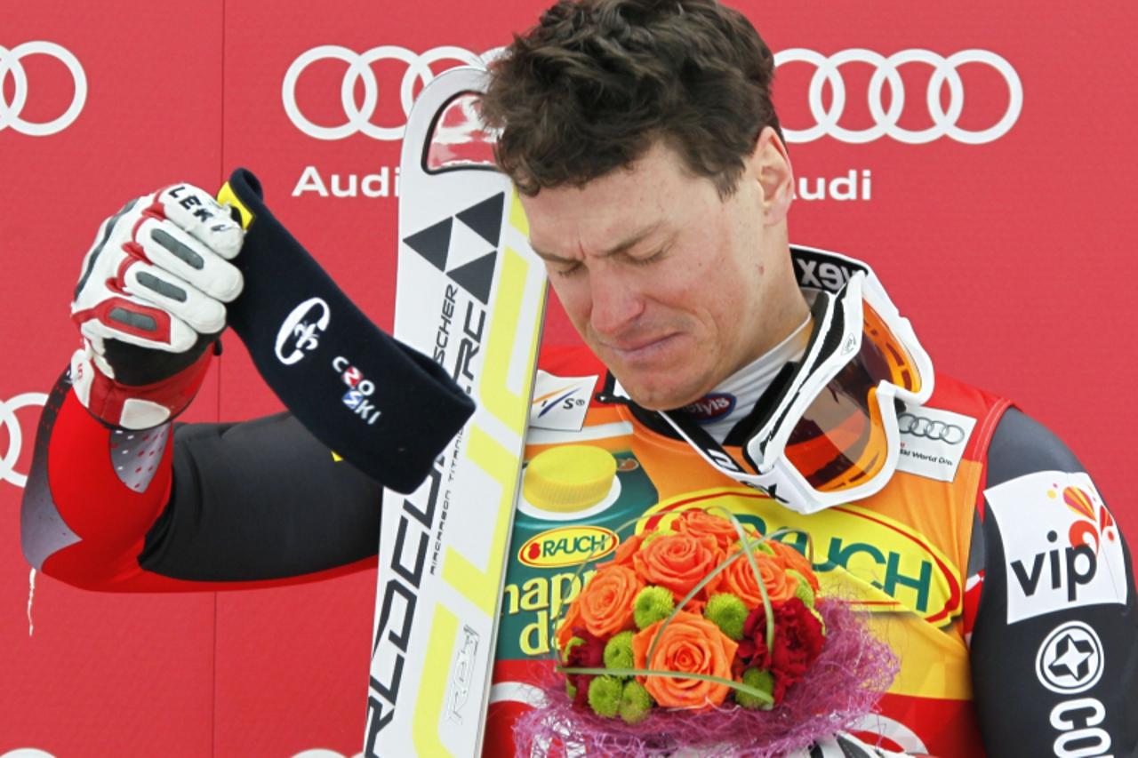 'Ivica Kostelic of Croatia grimaces in pain during the podium ceremony after winning the men\'s Alpine Skiing World Cup Super Combined event in Rosa Khutor near Sochi February 12, 2012. Kostelic injur