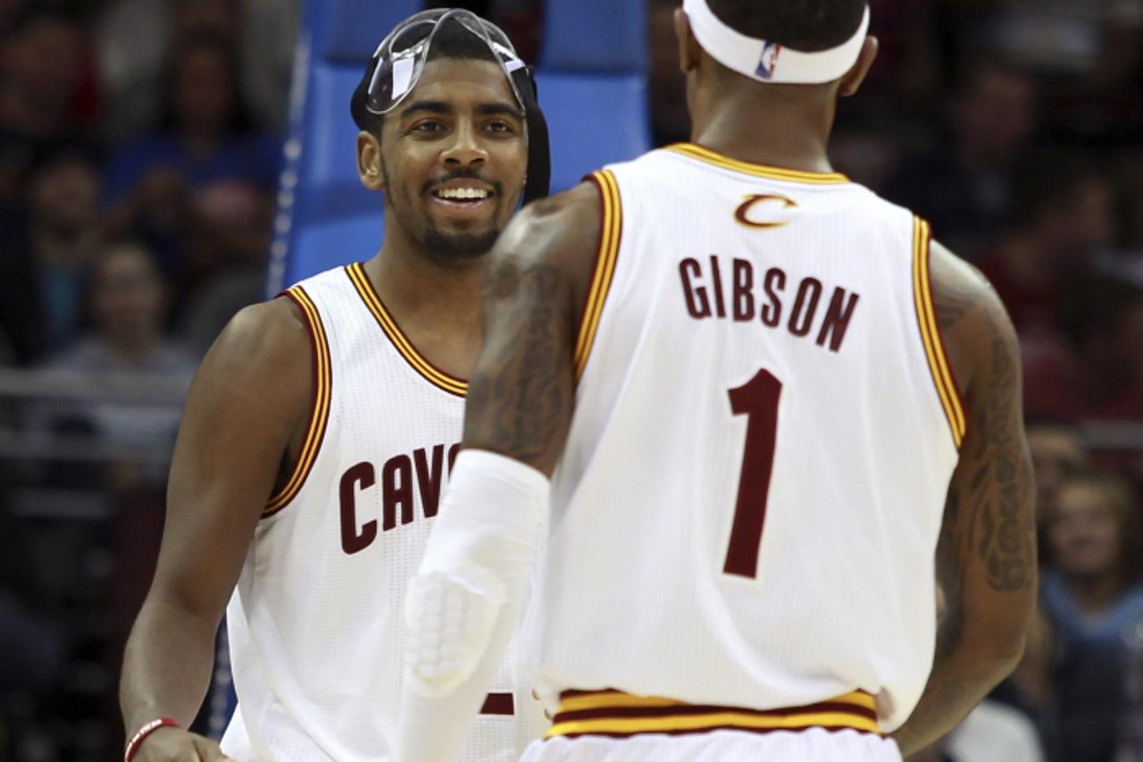 'Cleveland Cavaliers Kyrie Irving (L) smiles back at teammate Daniel Gibson during the second quarter of their NBA basketball game against the Toronto Raptors in Cleveland December 18, 2012. REUTERS/A