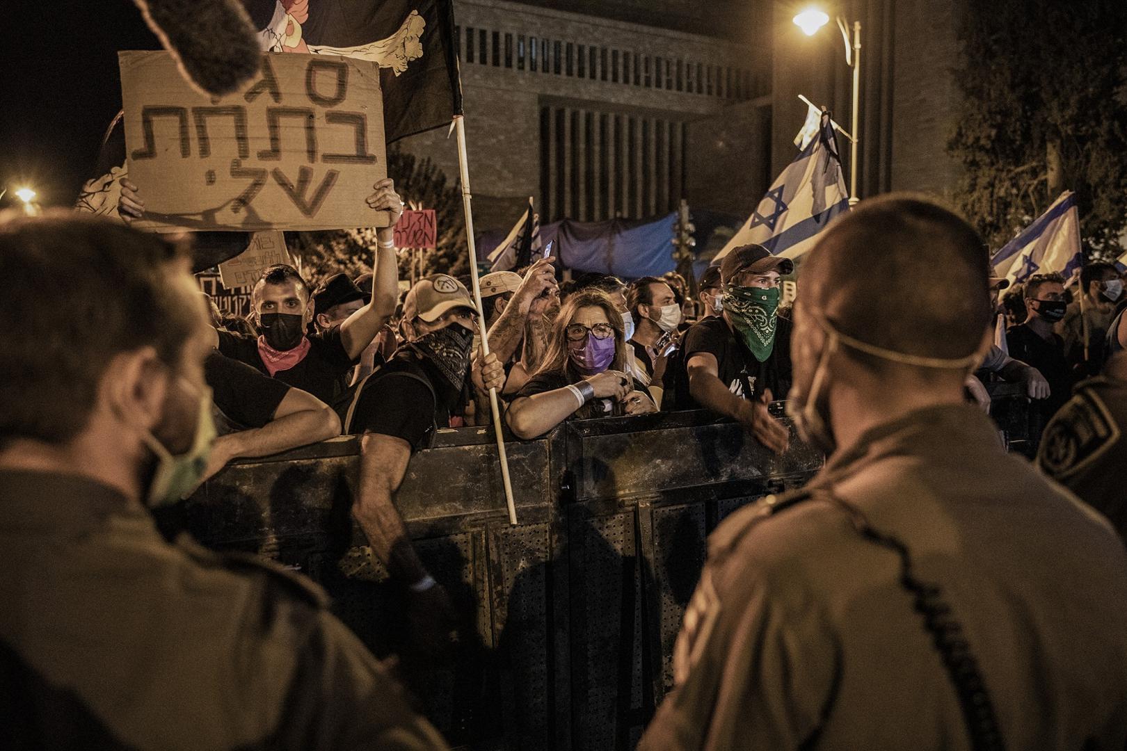 20 September 2020, Israel, Jerusalem: Israeli policemen watch as people hold placards and shout slogans during an anti-government demonstration against corruption outside the residence of Israeli Prime Minister Benjamin Netanyahu. Photo: Ilia Yefimovich/dpa /DPA/PIXSELL