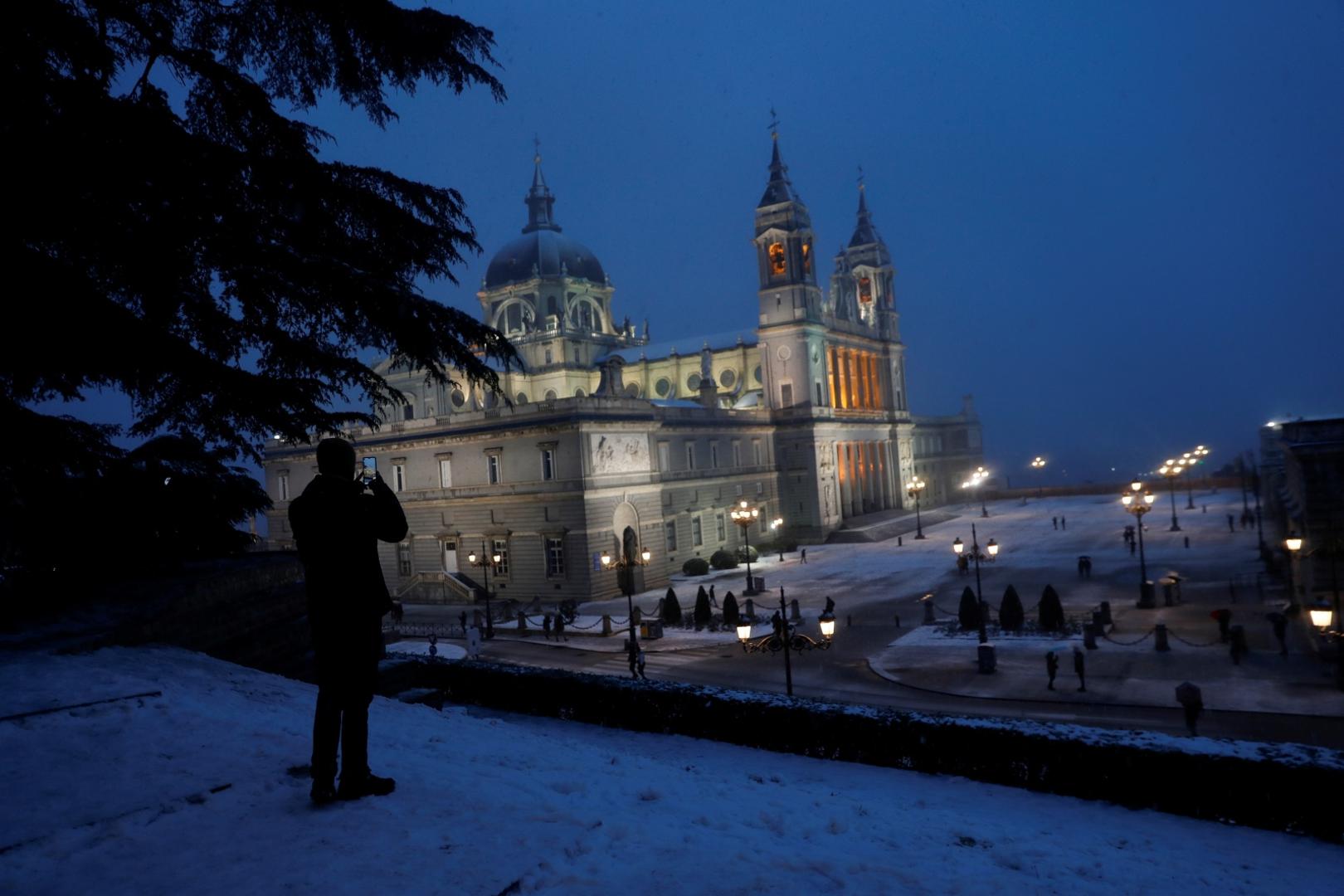 Heavy snowfall in Madrid A man takes a picture of Almudena Cathedral during heavy snowfall in Madrid, Spain January 8, 2021. REUTERS/Susana Vera SUSANA VERA