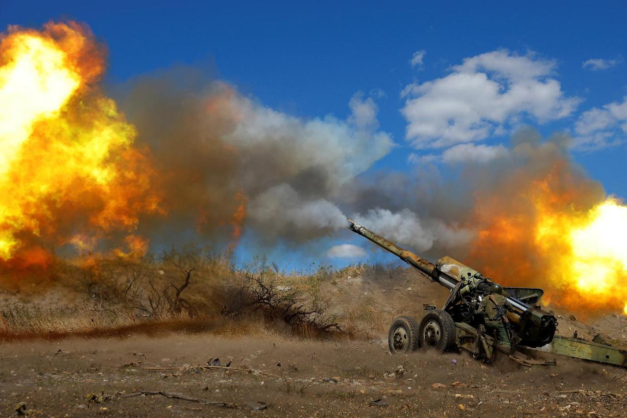 Service members of the self-proclaimed Donetsk People's Republic fire a Giatsint-B howitzer outside Donetsk