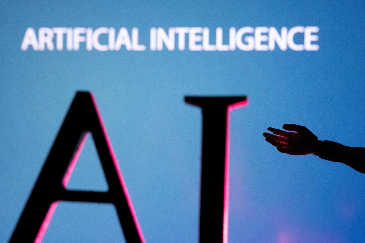 FILE PHOTO: FILE PHOTO: Illustration shows AI (Artificial Intelligence) letters and robot hand miniature