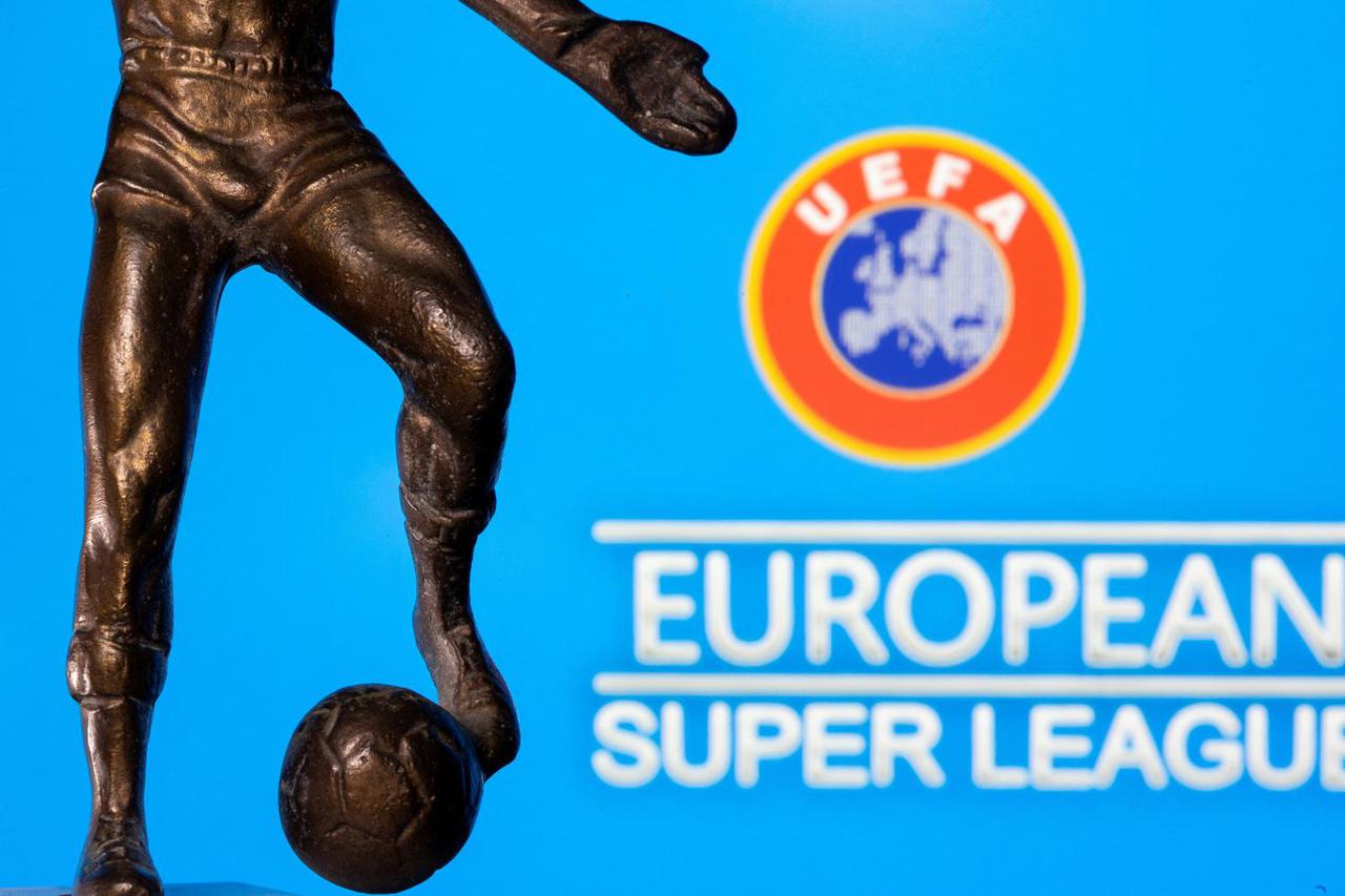 FILE PHOTO: A metal figure of a football player with a ball is seen in front of the words "European Super League" and the UEFA logo in this illustration