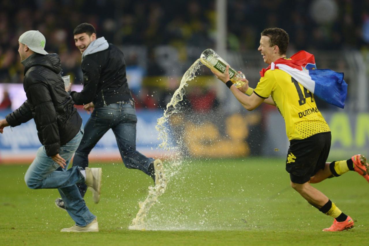 'Dortmund\'s Croatian midfielder Ivan Perisic (R) runs with a glas of beer to celebrate after winning the German first division Bundesliga football match Borussia Dortmund vs Borussia Moenchengladbach