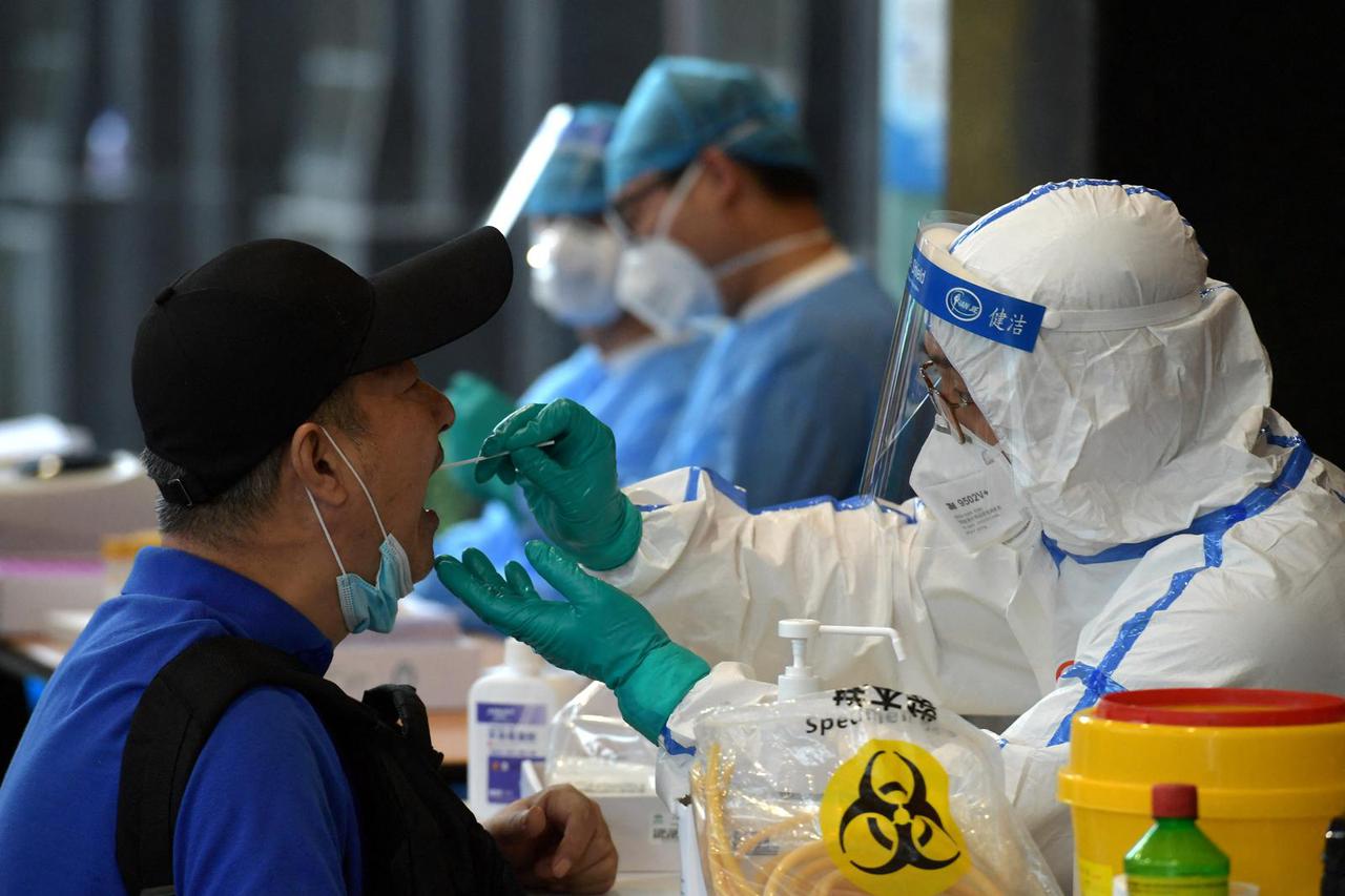 FILE PHOTO: Medical staff collects swabs from people who have recently travelled to Beijing for nucleic acid tests, in Nanjing