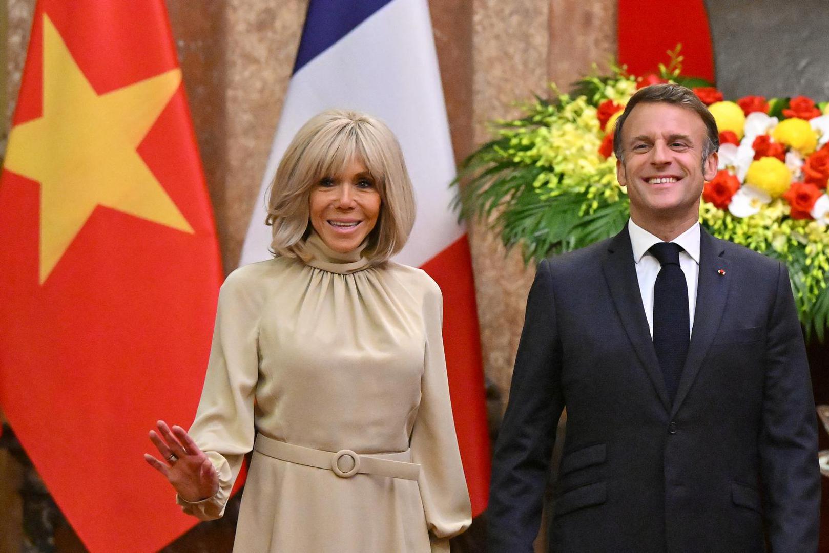 France's President Emmanuel Macron and his wife Brigitte Macron react as they pose for photos during a meeting at the Presidential Palace in Hanoi on May 26, 2025.     NHAC NGUYEN/Pool via REUTERS Photo: NHAC NGUYEN/REUTERS